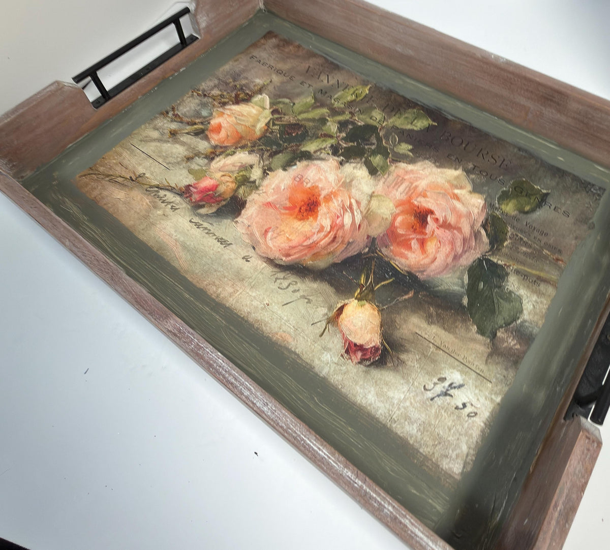 a wooden tray with a decorative floral print on it.