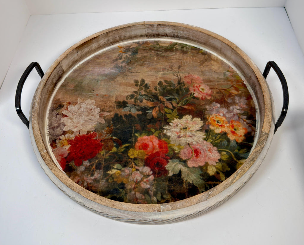 a round wooden tray with a floral design on its surface.