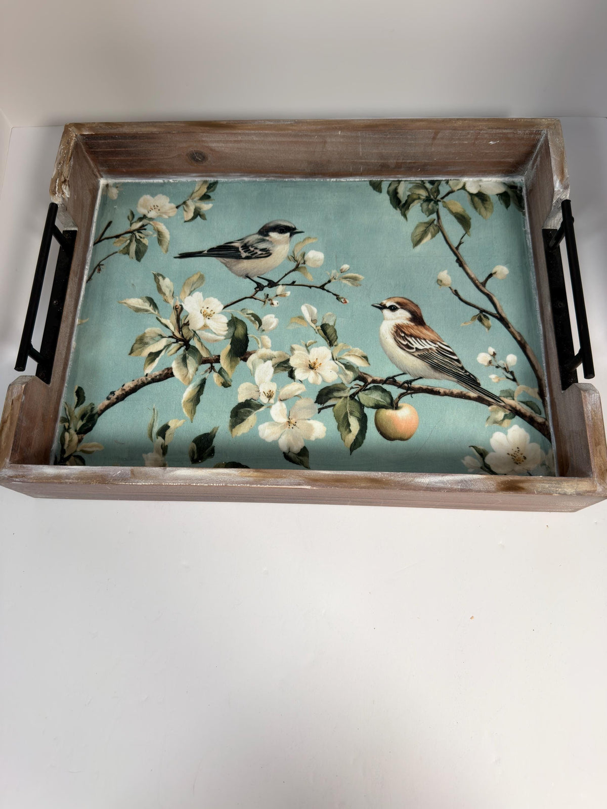 A wooden tray with a floral design featuring two birds perched on branches with white flowers.