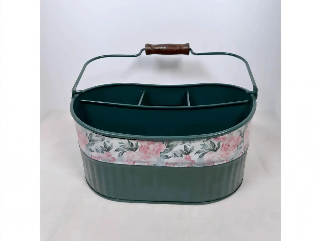A green metal basket with a floral pattern on the front, featuring a handle and three compartments.