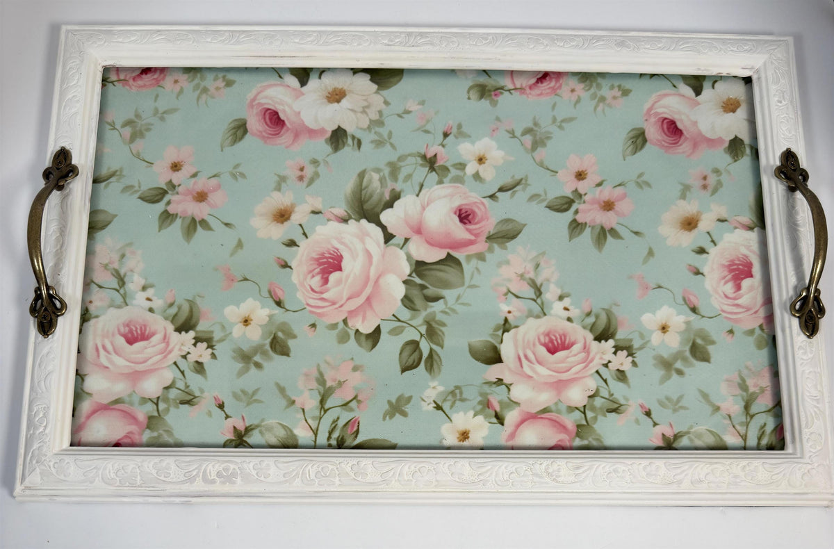 a white wooden frame with a floral pattern of pink and white roses on a light blue background.