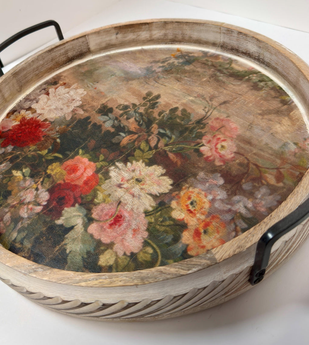 a wooden tray with a floral pattern painted on it.