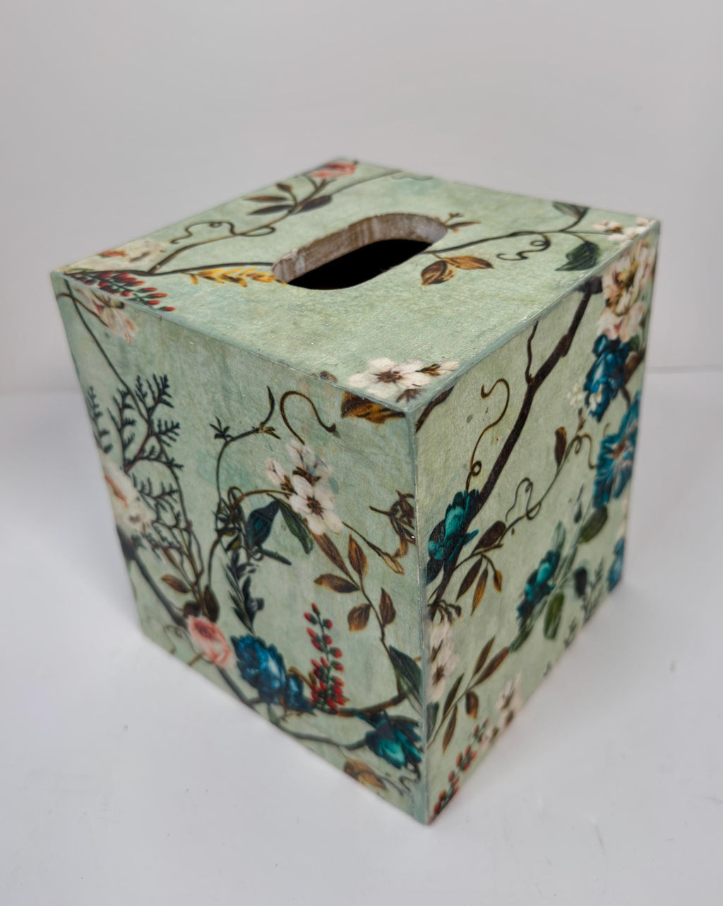 A square-shaped tissue box with a floral pattern on its surface.