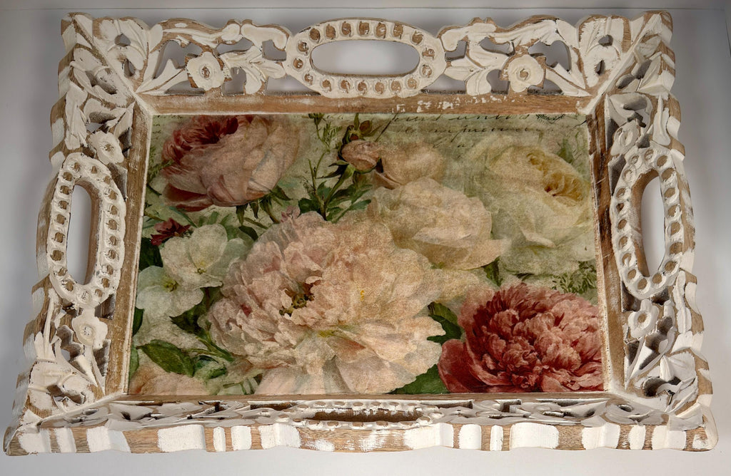 a decorative white tray with an ornate frame, displaying a floral arrangement of various colored flowers, including pink, white, and red blooms.