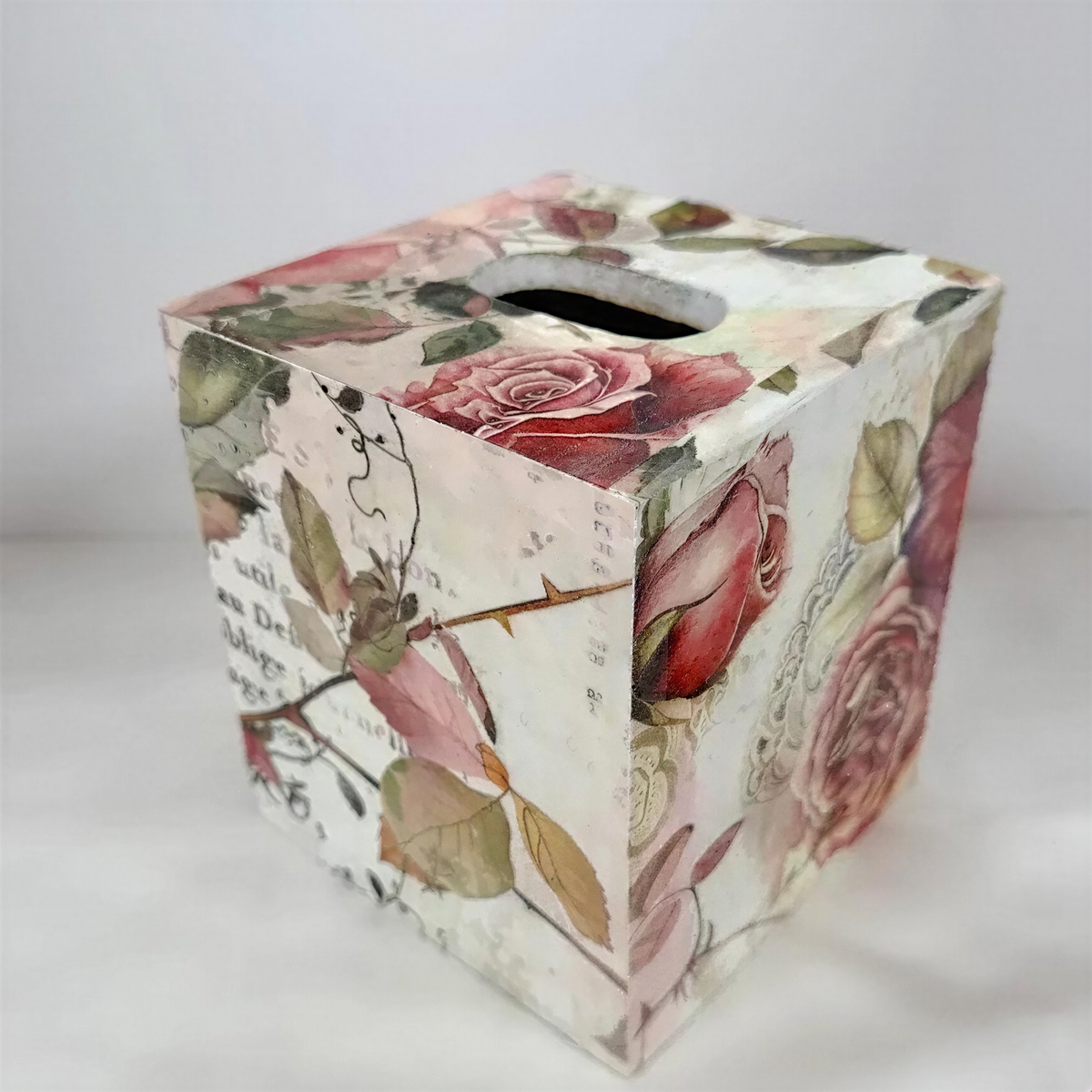 A wooden box with a floral pattern on its surface, featuring a rose design and other colorful flowers.