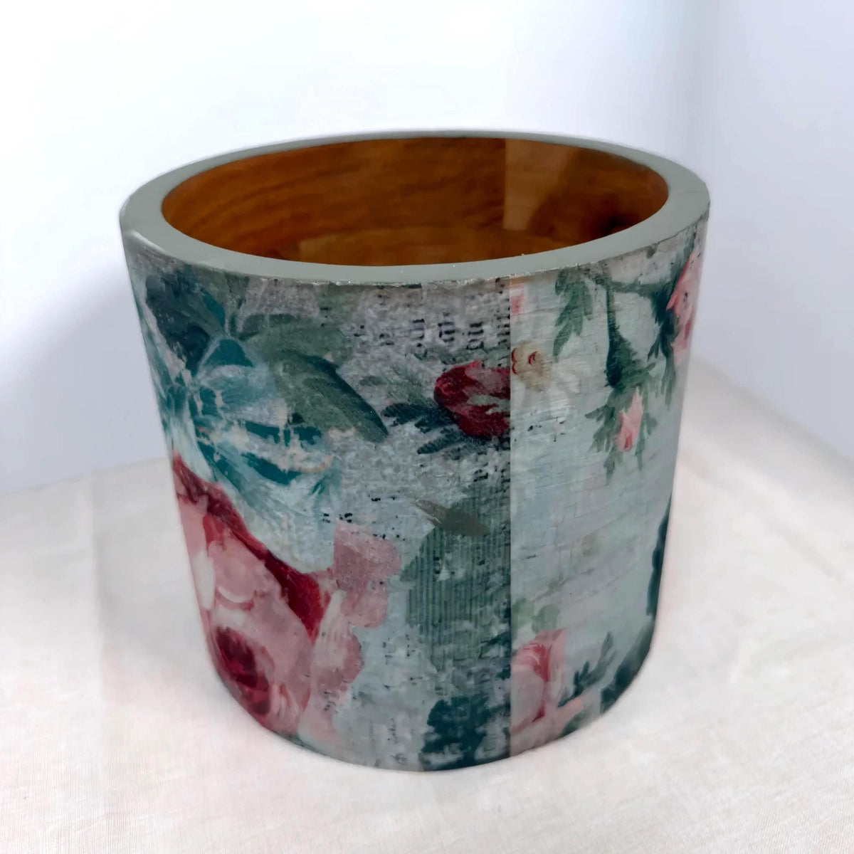 a cylindrical container with a floral pattern on its surface.
