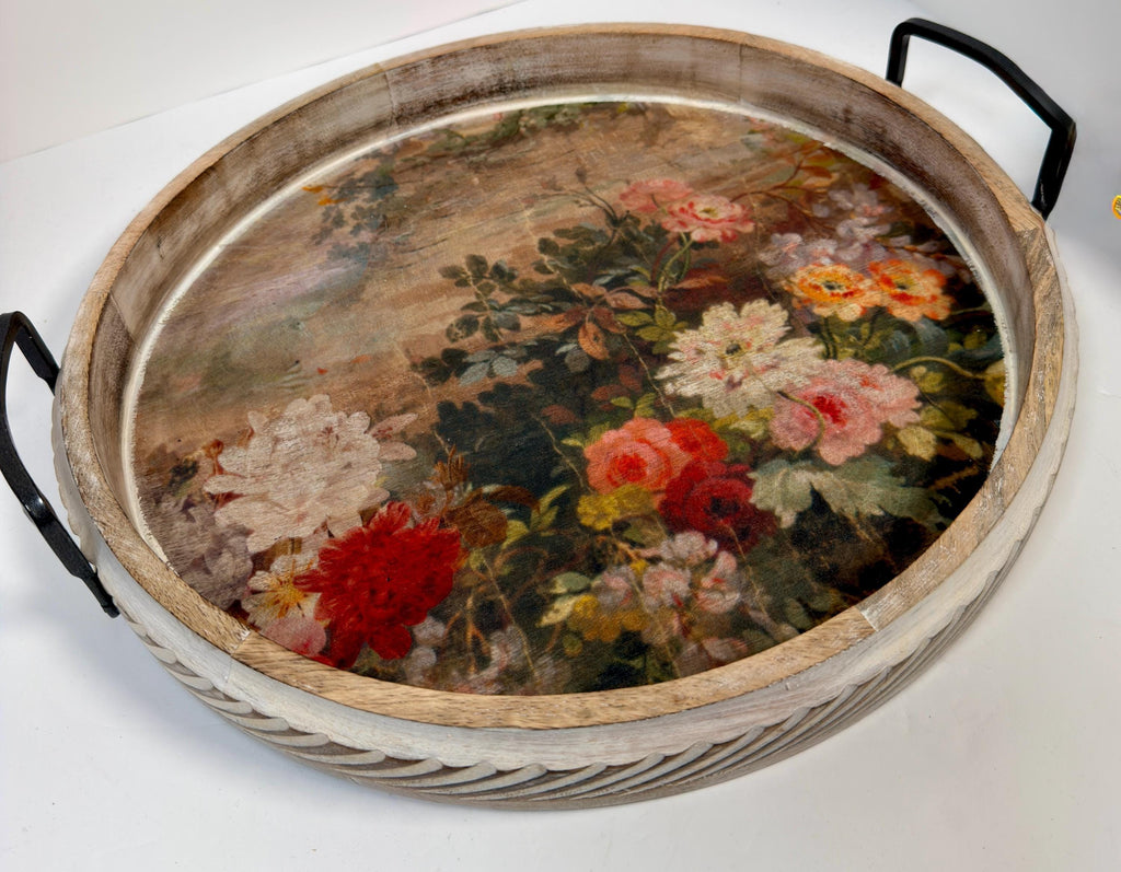 a round wooden tray with a floral design on its surface.