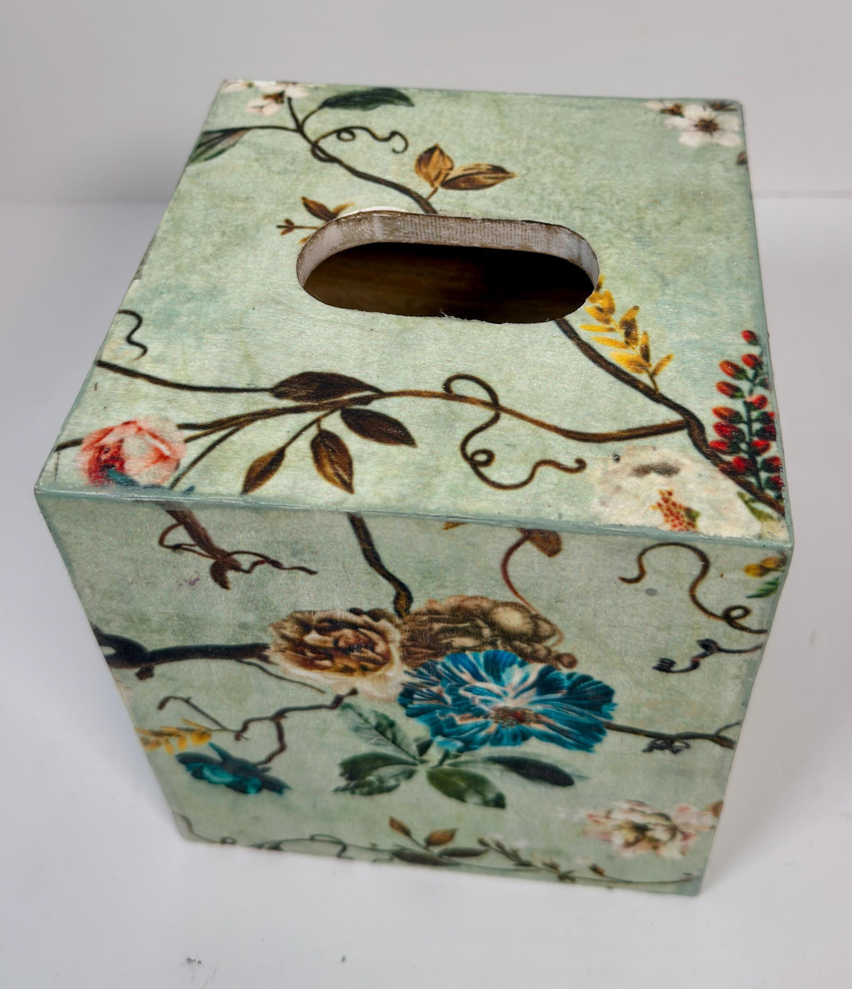 a square-shaped tissue box with a floral pattern on its surface.