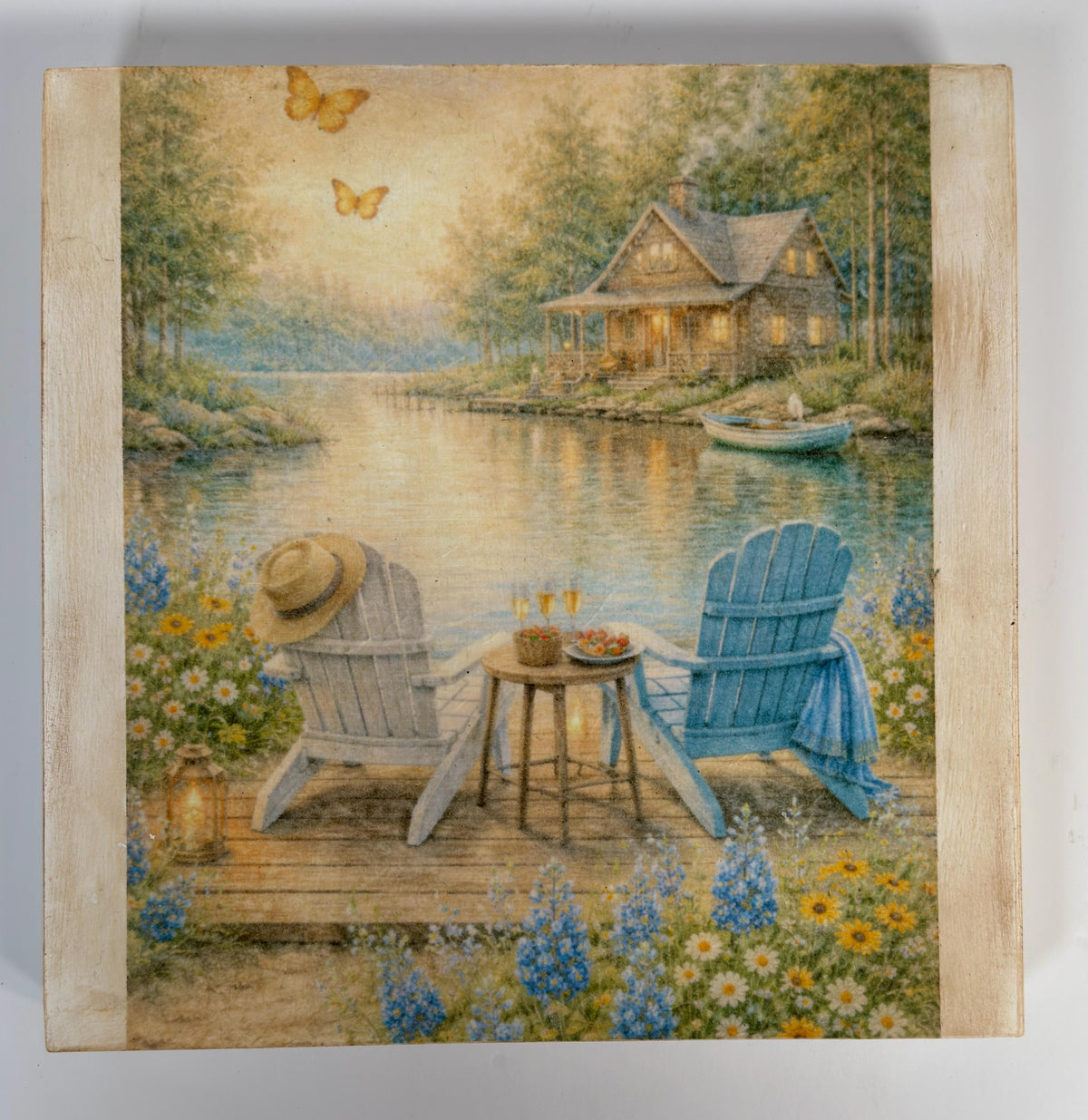 A serene lakeside scene with a cabin, two chairs, and a table set for a peaceful lakeside picnic. Butterflies are seen flying in the sky, and the water reflects the surrounding scenery.