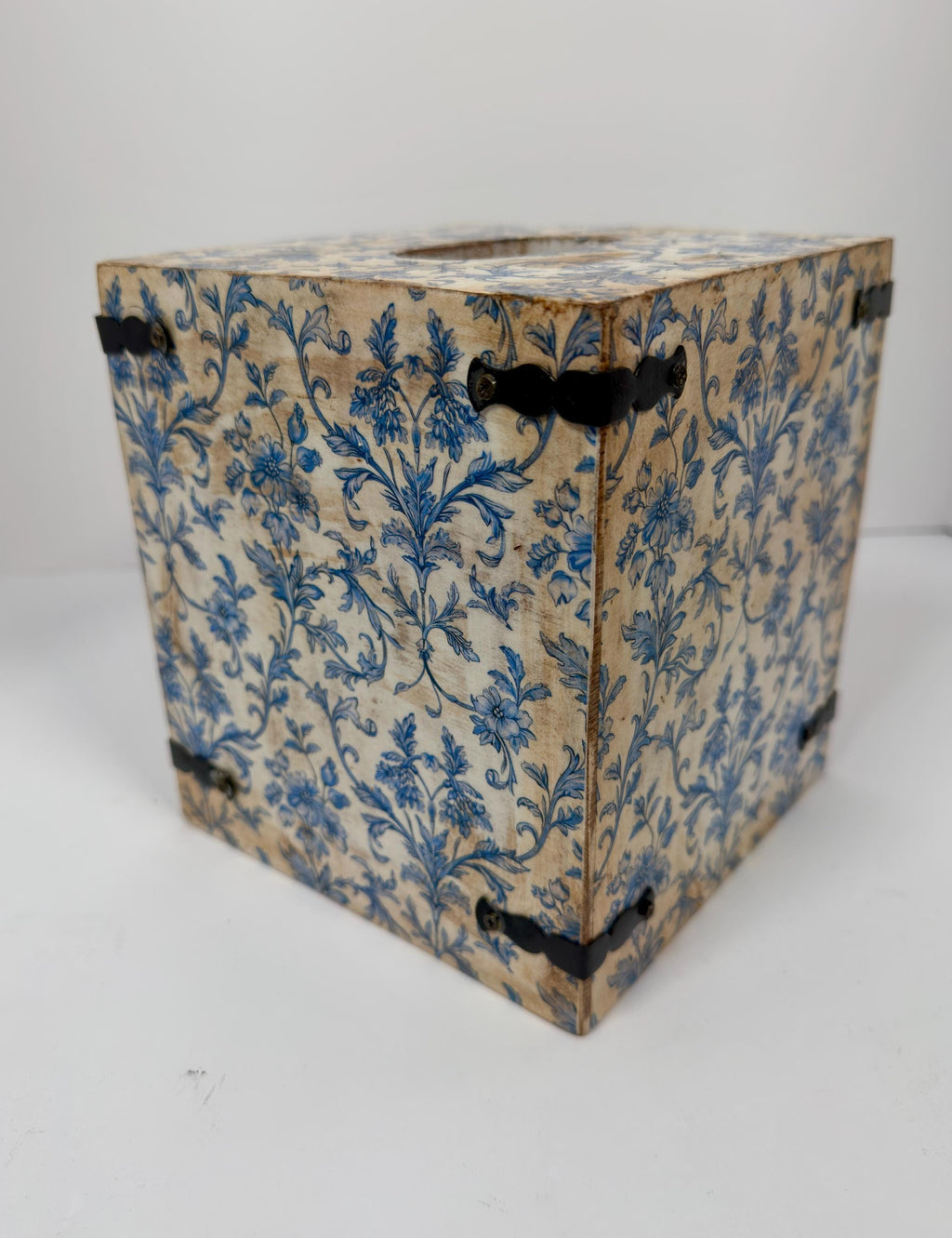 a wooden box with a blue floral pattern on its surface.