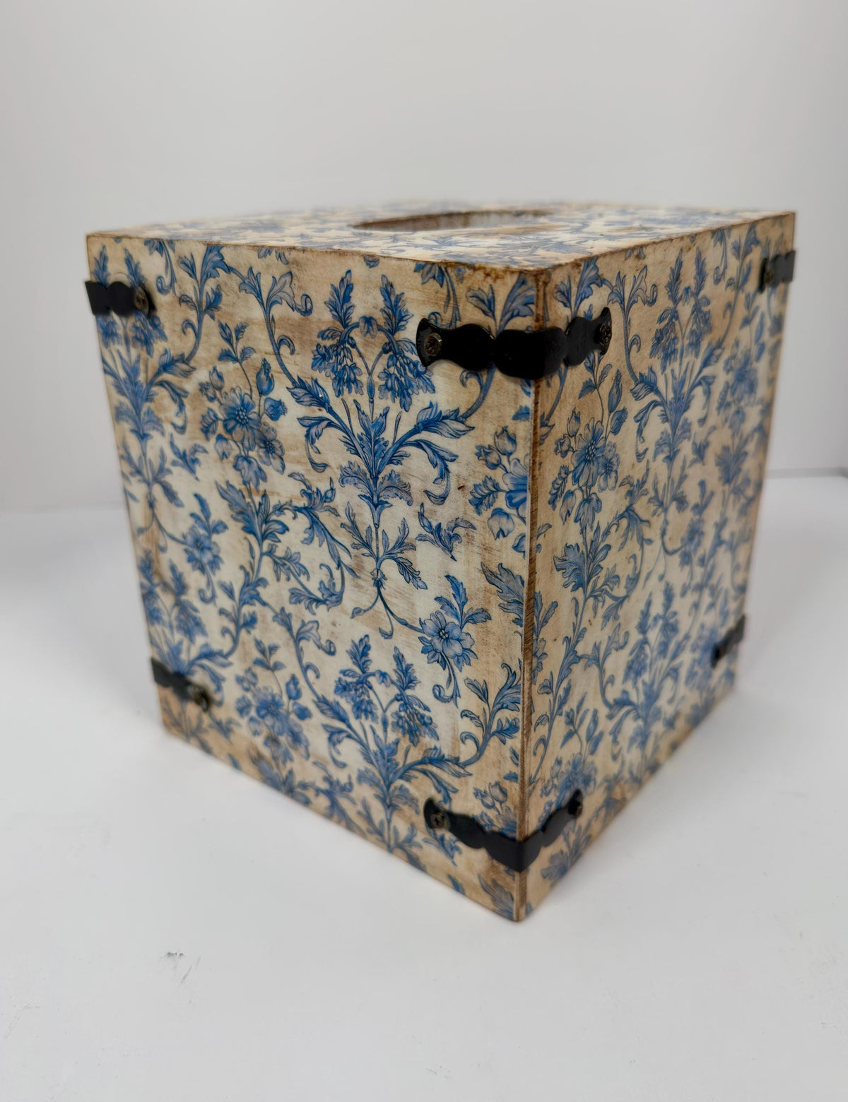 a wooden box with a blue floral pattern on its surface.