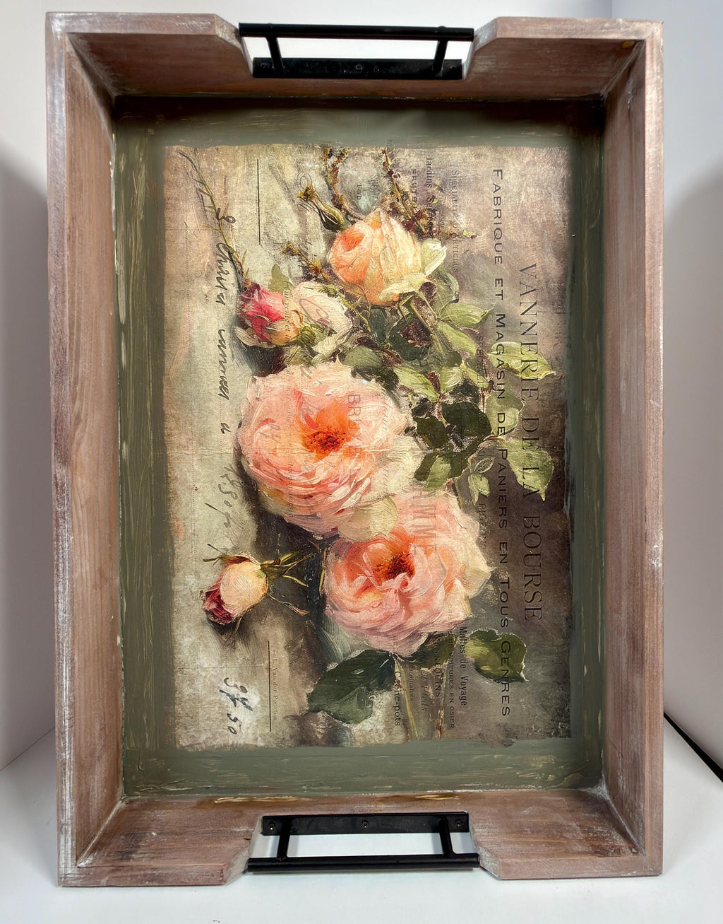 a wooden tray with a framed painting of pink roses on it.